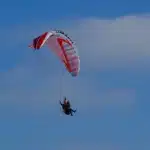 Ruimtecapsule met parachute landt in woestijn onder blauwe lucht