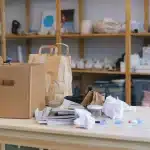 Volle afvalbakken met kartonnen dozen en verpakkingsmaterialen bij een gemeentelijk inzamelpunt