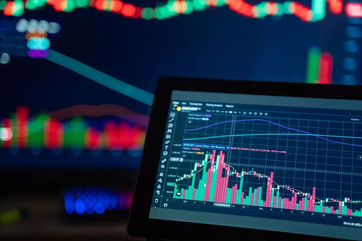 Handelaar analyseert aandelenkoersen en financiële data op meerdere schermen