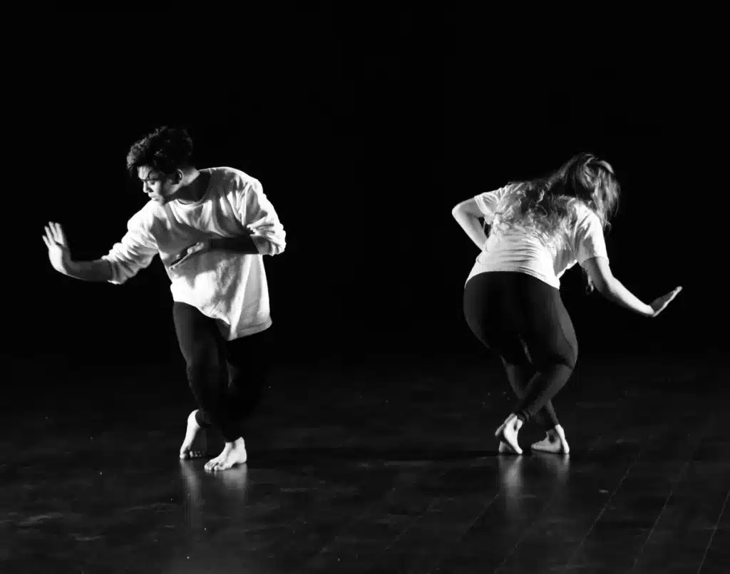 Twee dansers voeren een hedendaagse duet uit in een dansatelier