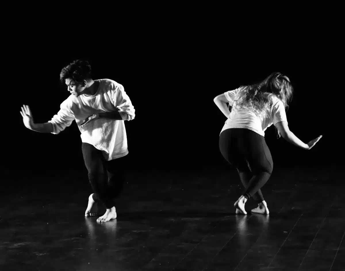 Twee dansers voeren een hedendaagse duet uit in een dansatelier