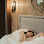 Persoon in bed die worstelt met slaap in een donkere slaapkamer