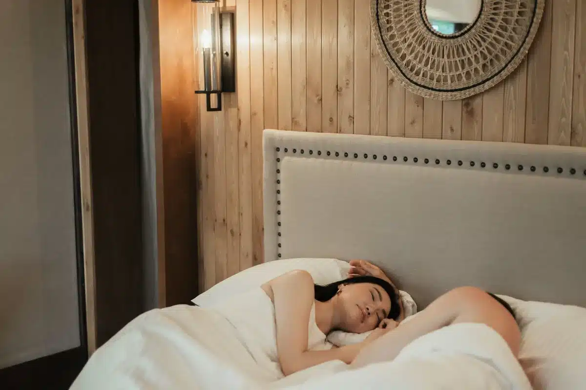 Persoon in bed die worstelt met slaap in een donkere slaapkamer