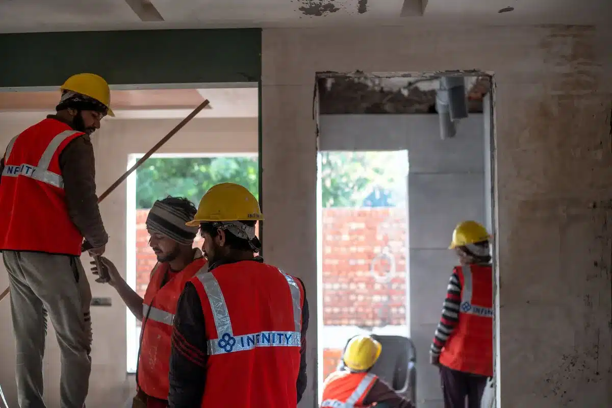 Bouwvakkers werken aan de renovatie van de foyer van het theater met gereedschap en houten materialen.