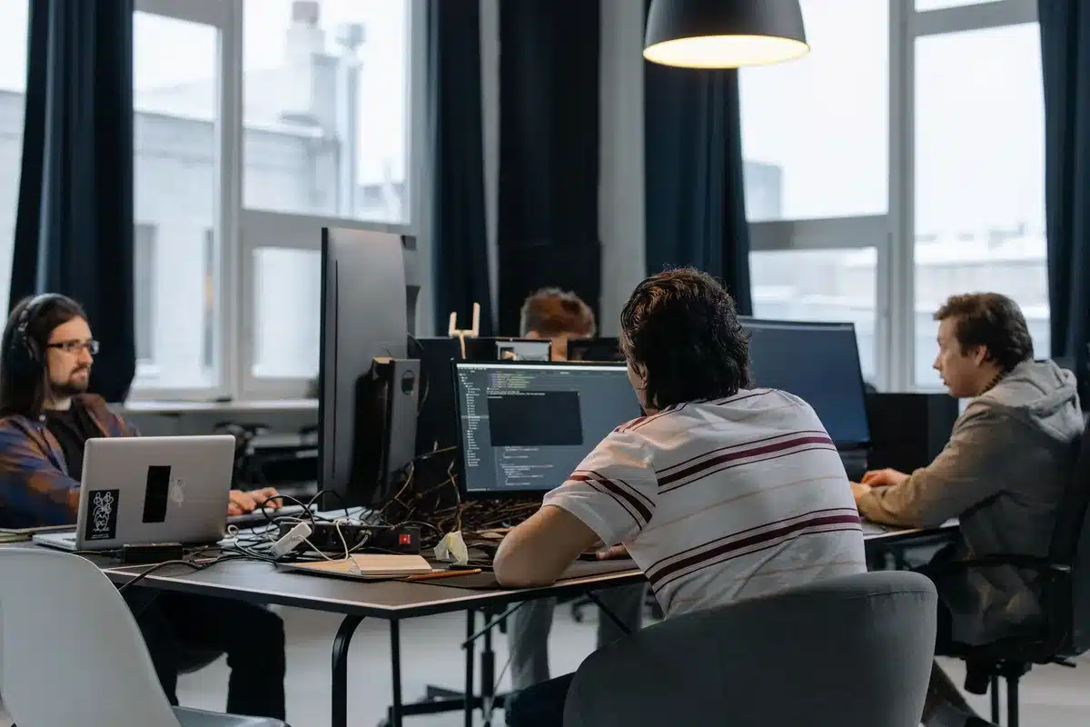Softwareontwikkelaars aan het werk in een modern kantoor met computers en schermen