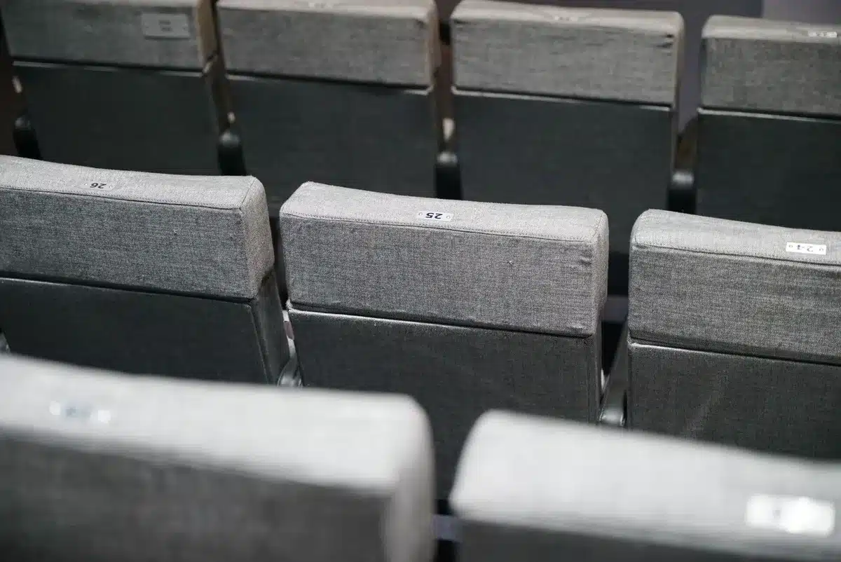 Technicus test de geluiddempende stoelmechanisme van een nieuwe theaterzetels