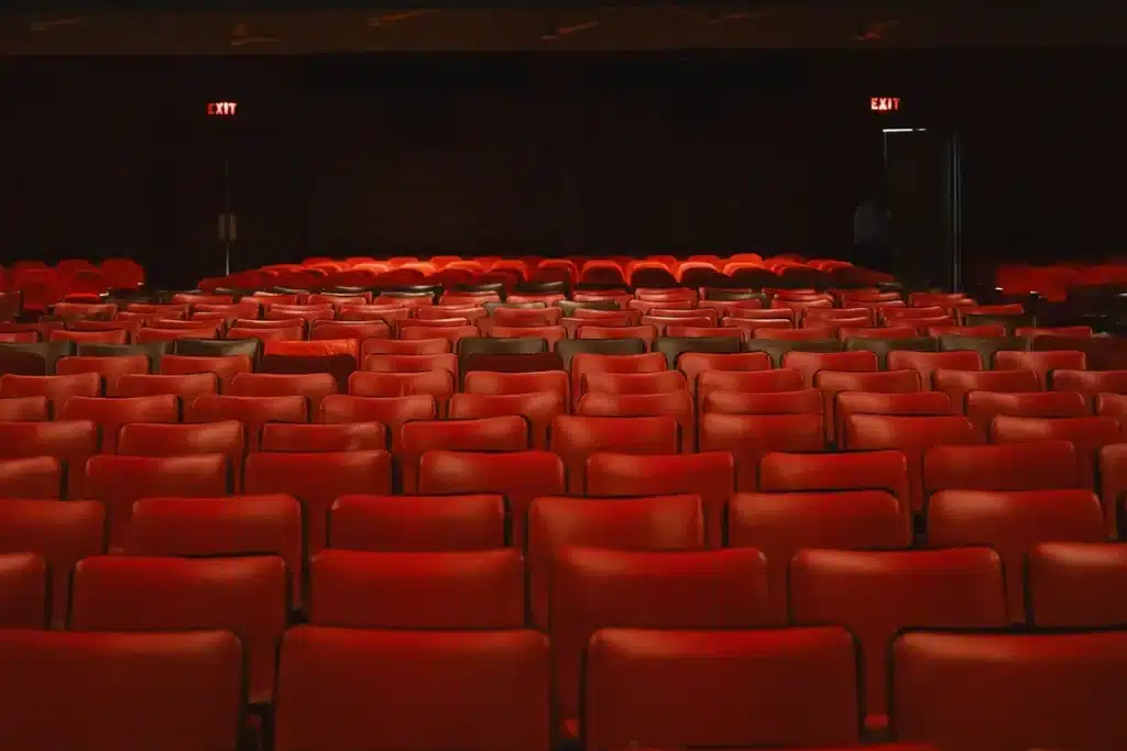 Rijen rode fluwelen bioscoopstoelen in een elegant theater interieur