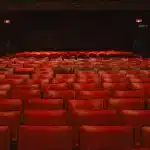 Rijen rode fluwelen bioscoopstoelen in een elegant theater interieur