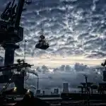 Silhouet van een arbeider bij productielijn, landbouwcontainers en vrachtwagen op afstand