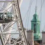 Mensen als silhouetten kijken naar een grote maan boven een stadsgezicht tijdens verduistering