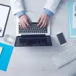 Dokter bekijkt medische onderzoeksgegevens met sceptische uitdrukking aan bureau
