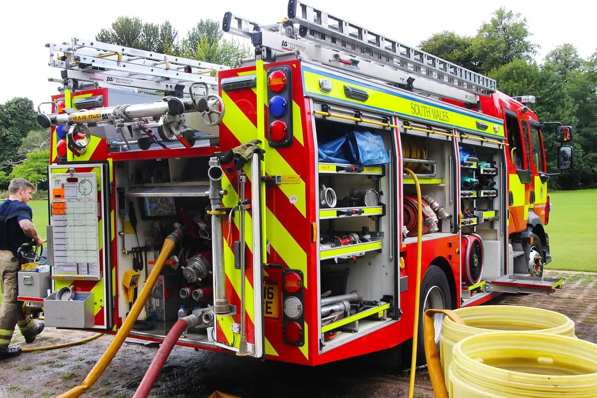 Brandweerlieden bij een vliegtuig met een ladder naast de staartvin