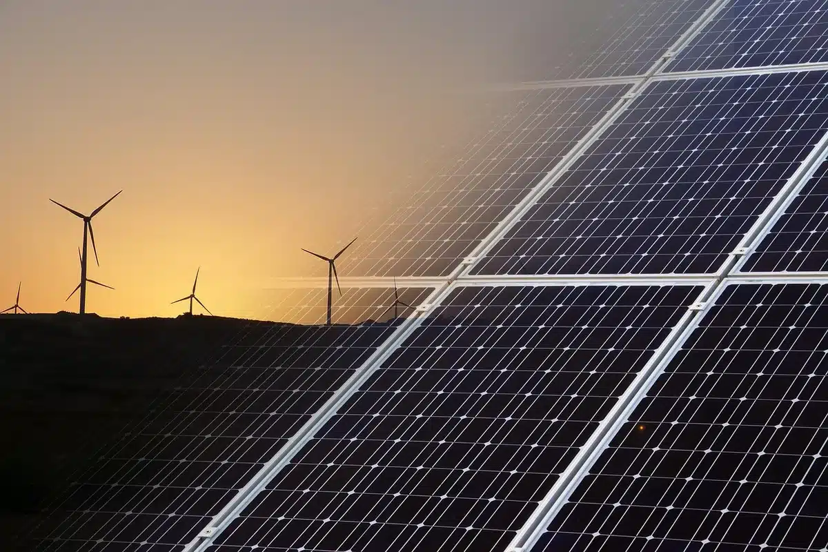 Zonnepanelen en windmolens in een landschap, representatief voor Shells desinvesteringen in hernieuwbare energie