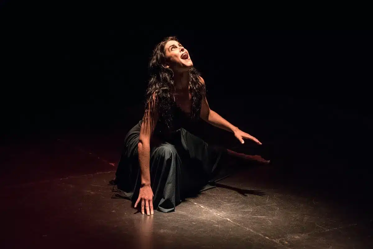 Mthuthuzeli November repeteert op scène met dansers in spotlicht