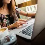 Open kantoorruimte met laptop, modecatalogi en een silhouet; sfeer van urgentie