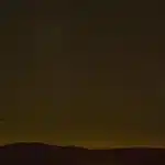 Nachtelijke hemel met vallende sterren en meteorensporen boven een donker landschap
