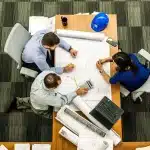 Hands holding documents and folders on a meeting table, symbolising cultural policy change