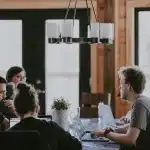Silhouet van een kleine startup-vergadertafel met laptops en notities